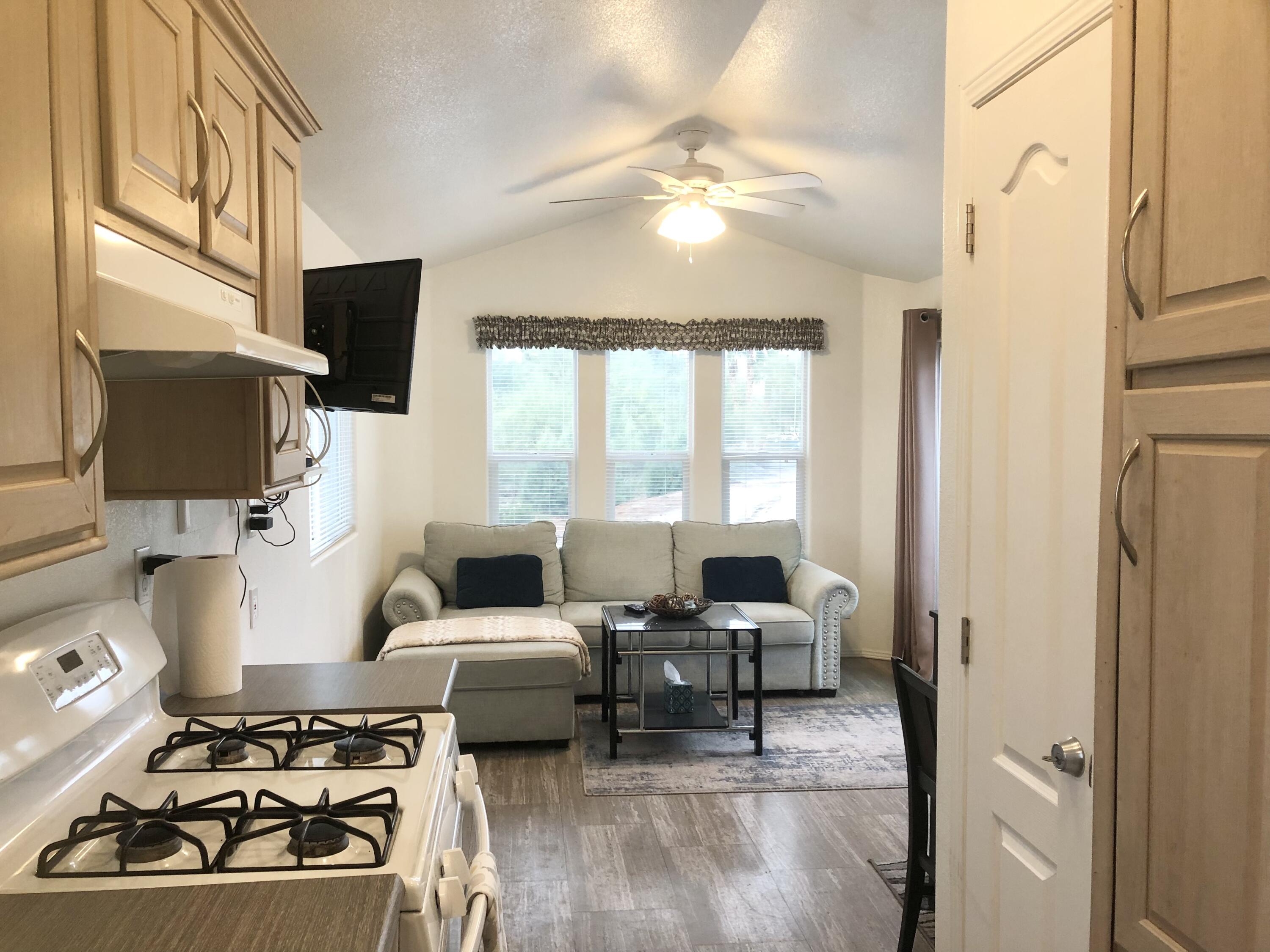 74711 Dillon Road Desert Hot Springs, CA 92241 - Photo 6 of 41 a living room with furniture a flat screen tv and a fireplace