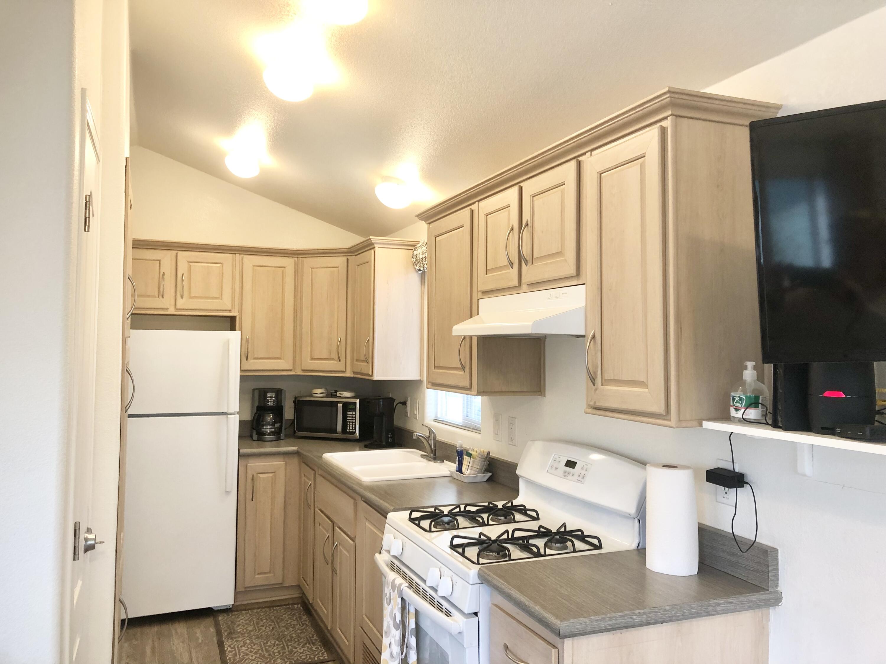 74711 Dillon Road Desert Hot Springs, CA 92241 - Photo 7 of 41 a kitchen with a refrigerator a stove a sink and a cabinets