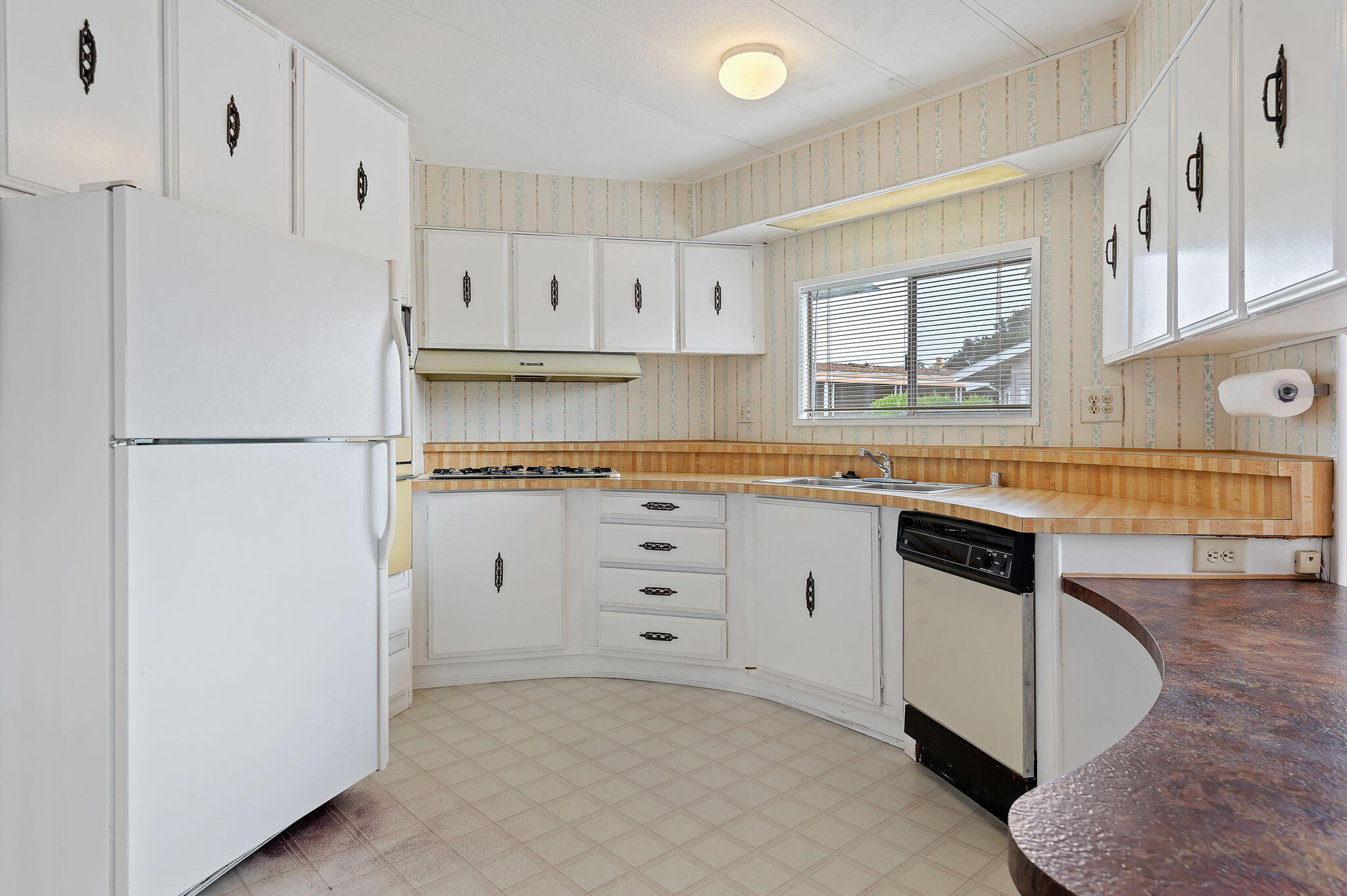 333 Old Mill Road, Unit 157 Santa Barbara, CA 93110 - Photo 6 of 12 a kitchen with granite countertop white cabinets and white appliances