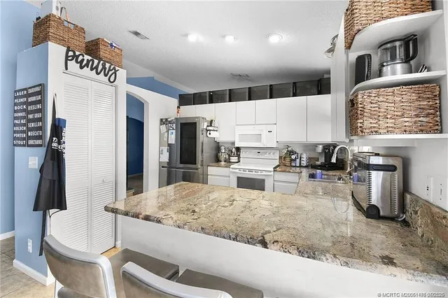 a kitchen with stainless steel appliances kitchen island granite countertop a sink refrigerator and stove