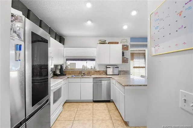 a kitchen with a sink a refrigerator and cabinets