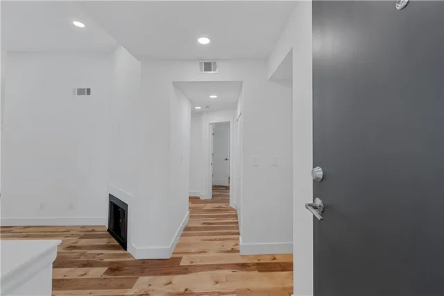 a view of a hallway with wooden floor and staircase