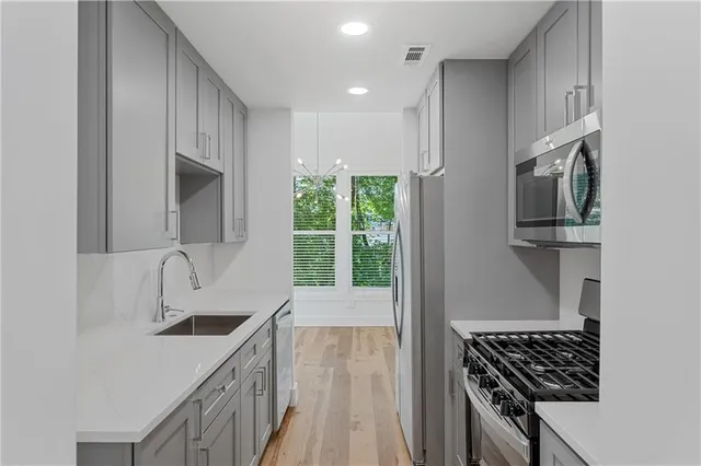 a kitchen with stainless steel appliances a sink stove and cabinets