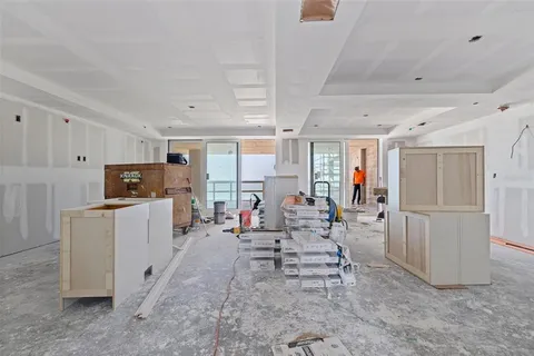 a living room with furniture and a refrigerator