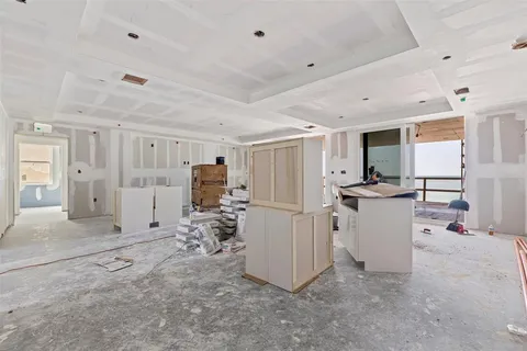 a view of a kitchen with refrigerator and white cabinets