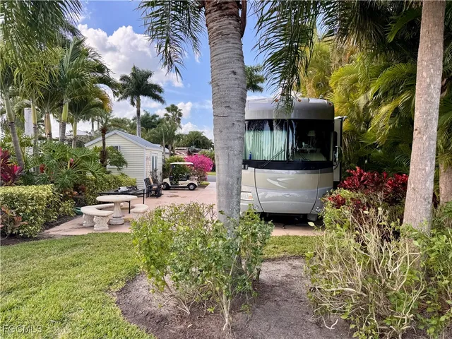 a view of a house with a yard and potted plants