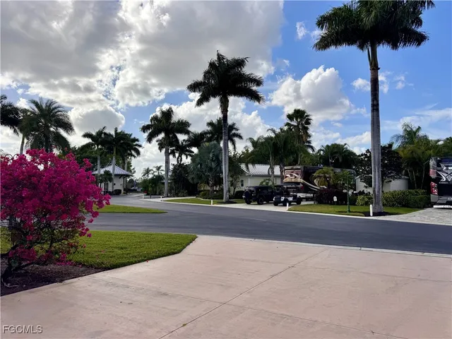 a front view of a house with a garden and tree