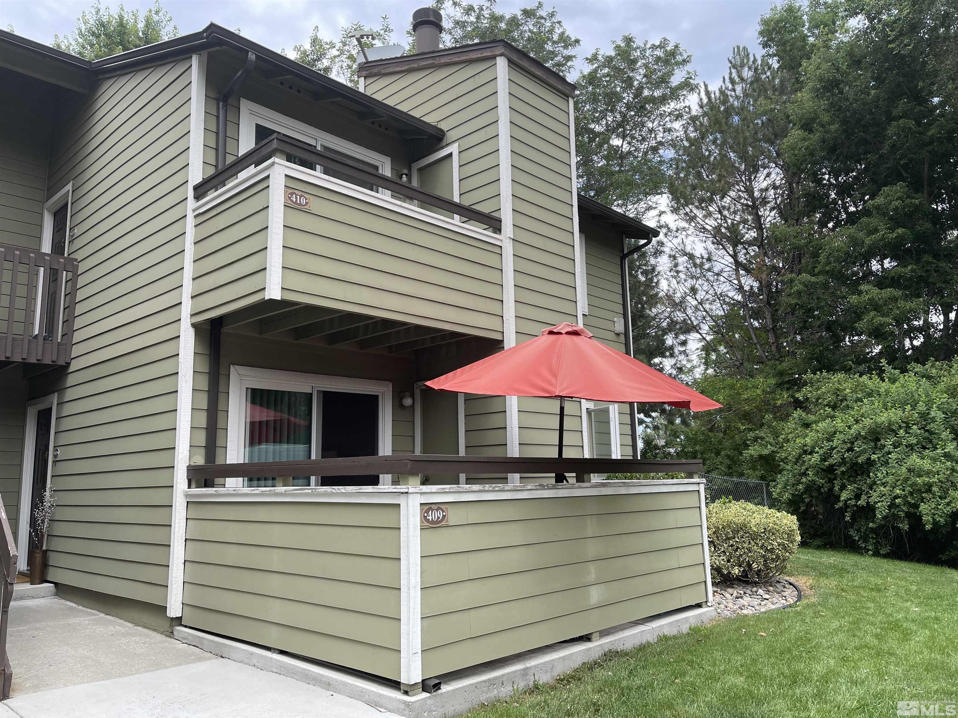 7680 Bluestone Drive, Unit 409 Reno, NV 89511 - Photo 1 of 16 a view of a house with a yard and a large tree