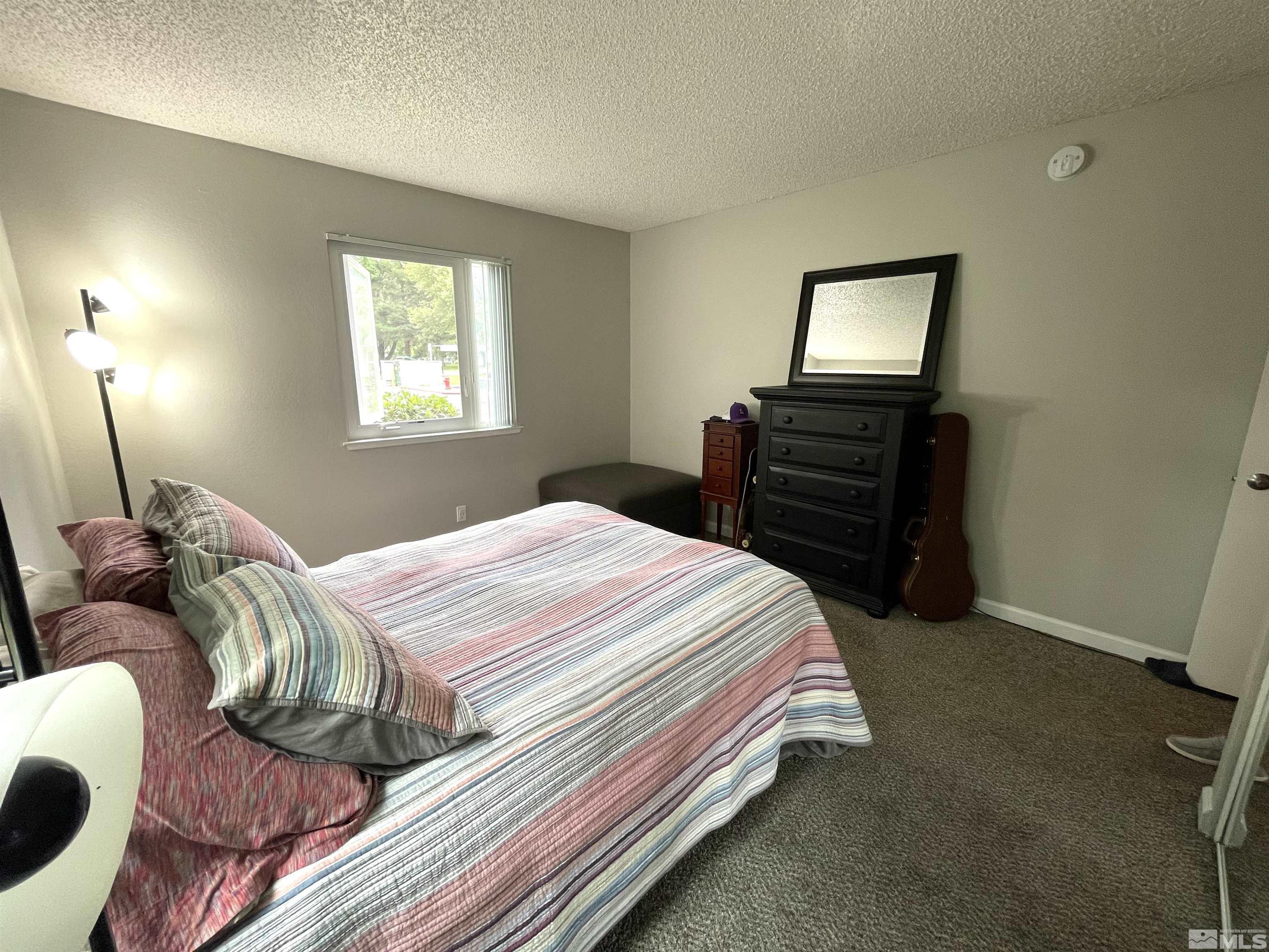 7680 Bluestone Drive, Unit 409 Reno, NV 89511 - Photo 13 of 16 a bedroom with a bed and a tv