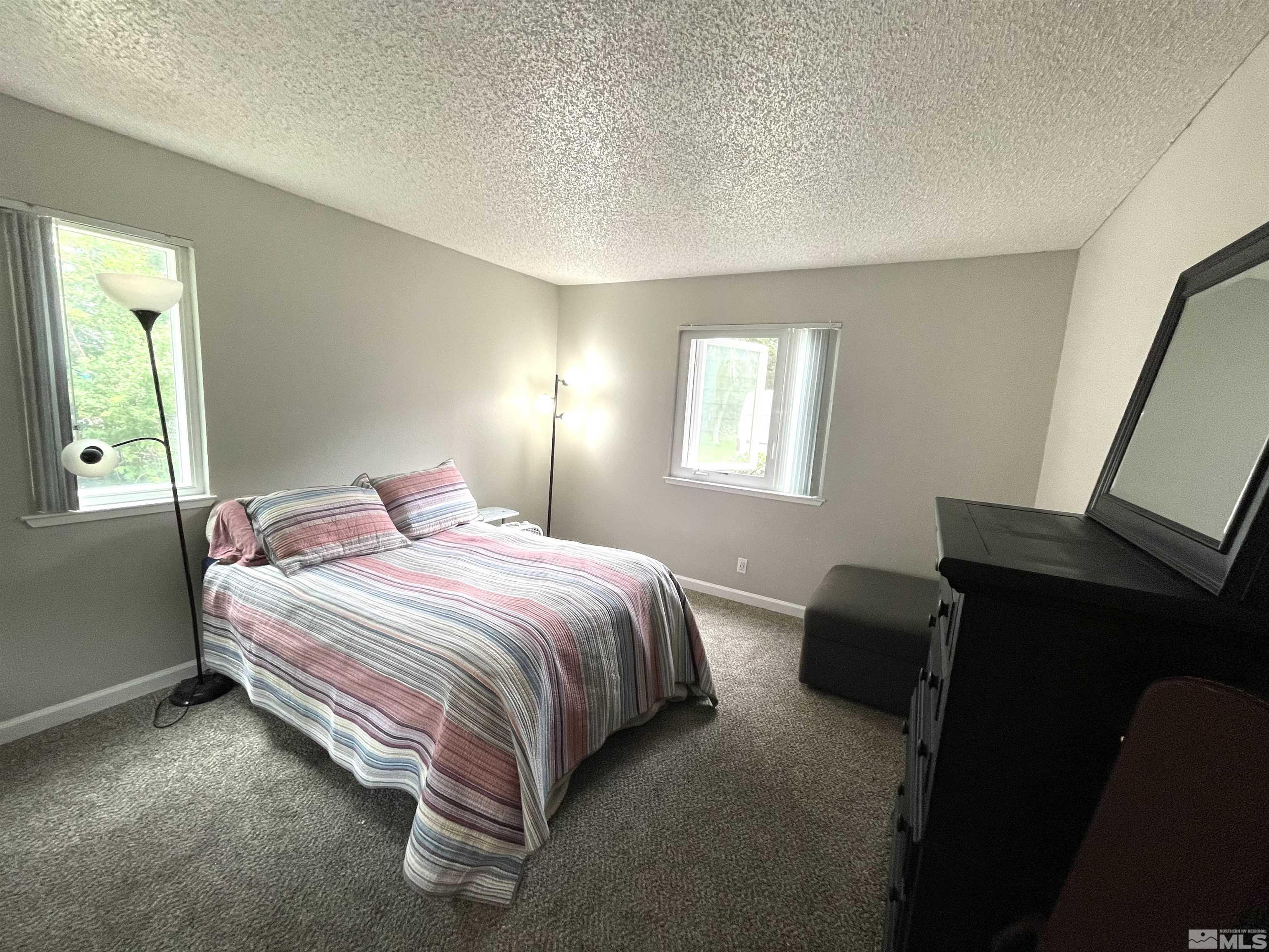 7680 Bluestone Drive, Unit 409 Reno, NV 89511 - Photo 14 of 16 a bedroom with a bed and a window