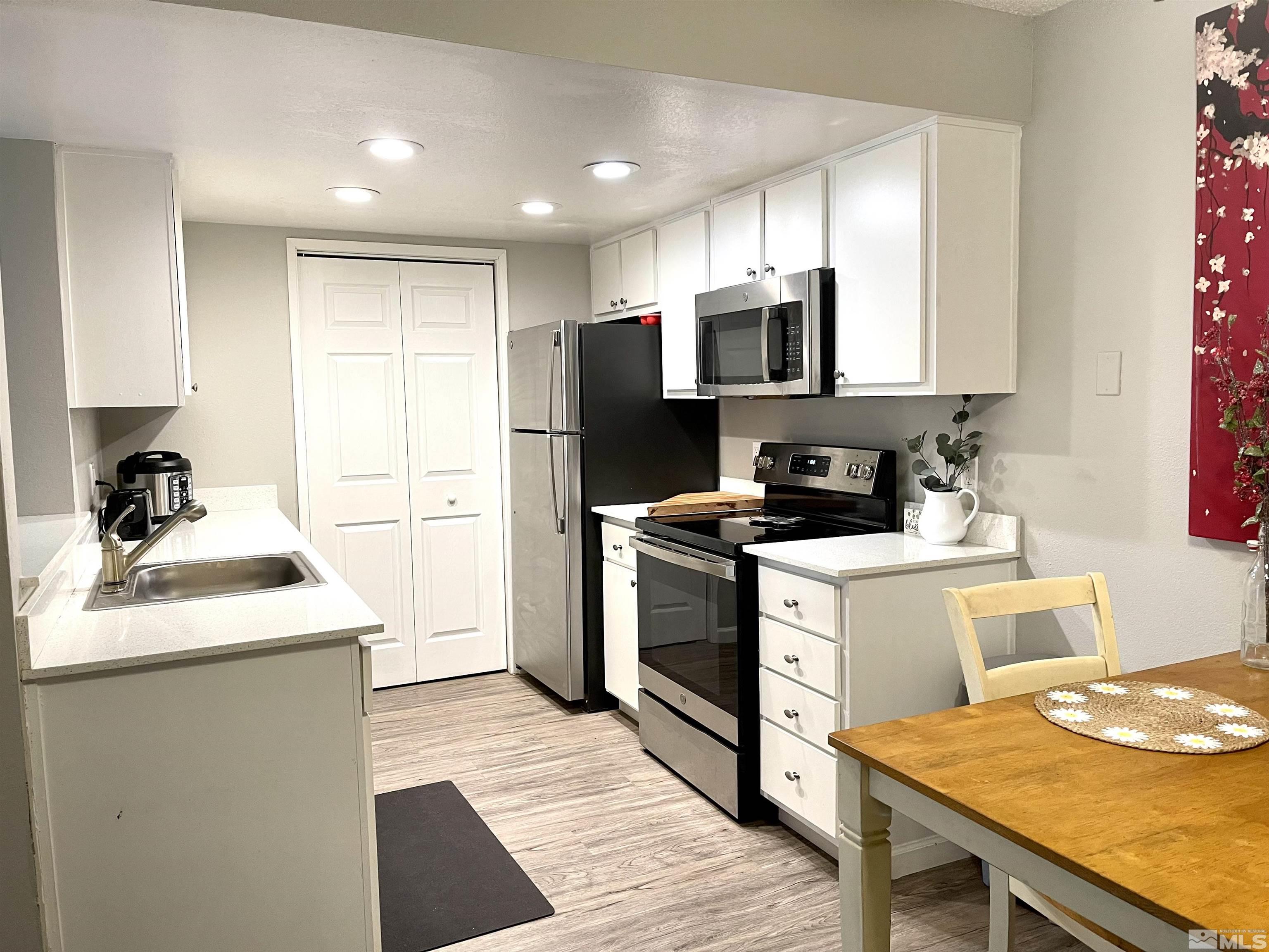7680 Bluestone Drive, Unit 409 Reno, NV 89511 - Photo 3 of 16 a kitchen with a sink a stove a refrigerator and cabinets