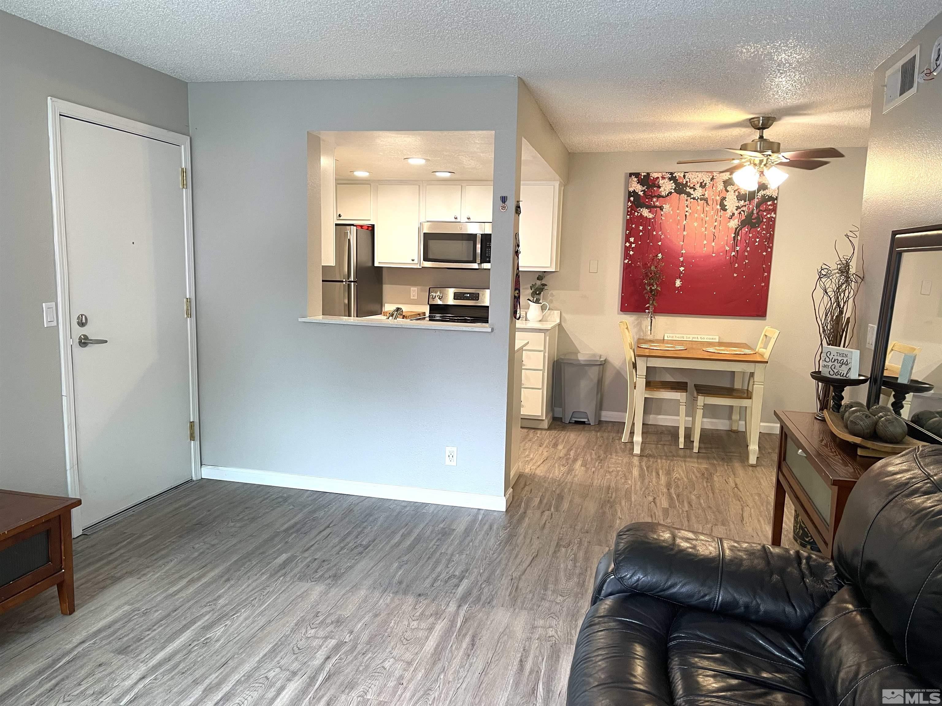 7680 Bluestone Drive, Unit 409 Reno, NV 89511 - Photo 5 of 16 a living room with furniture and a flat screen tv