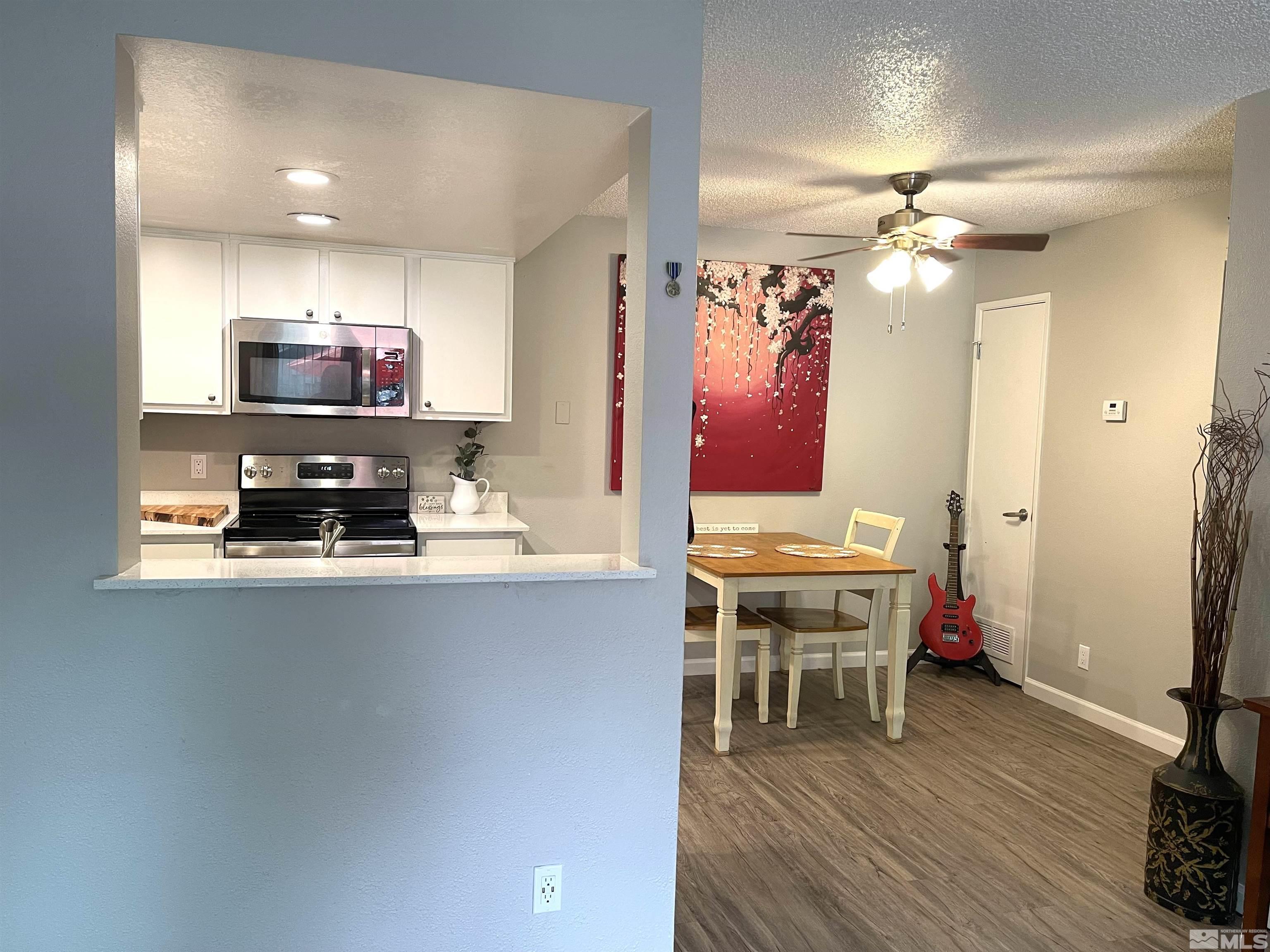 7680 Bluestone Drive, Unit 409 Reno, NV 89511 - Photo 7 of 16 a living room with stainless steel appliances furniture and a flat screen tv