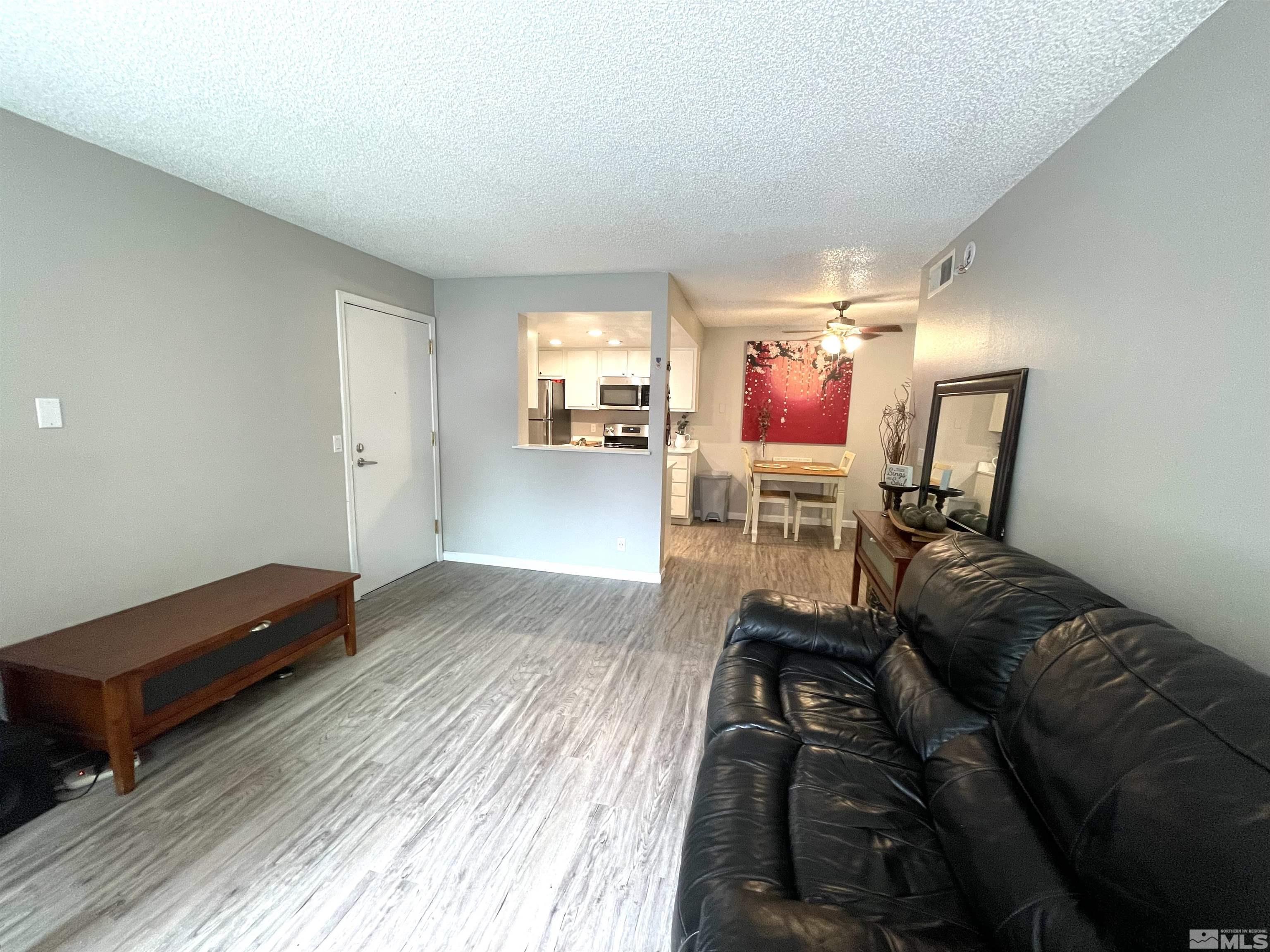 7680 Bluestone Drive, Unit 409 Reno, NV 89511 - Photo 8 of 16 a living room with furniture and a wooden floor