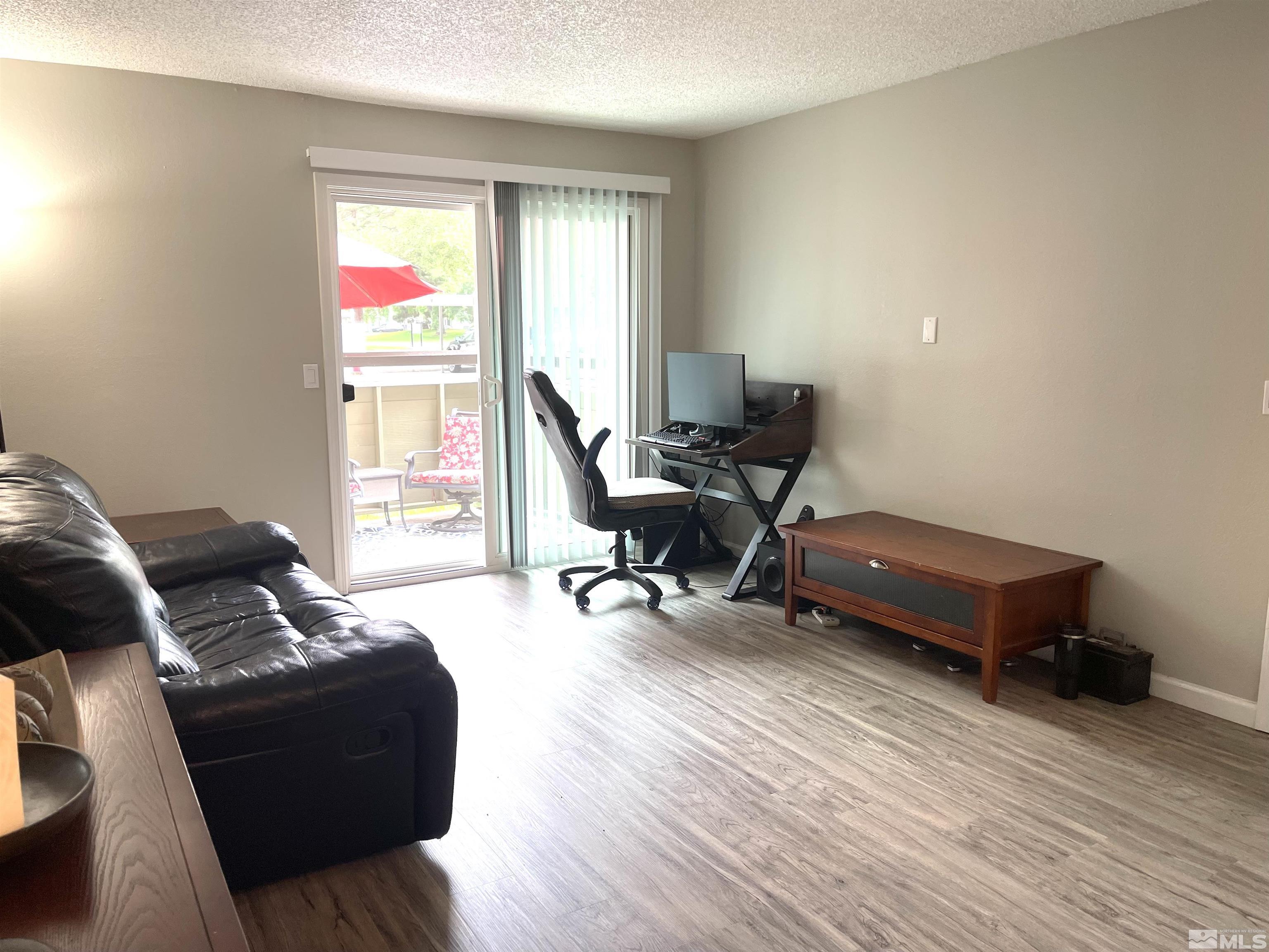 7680 Bluestone Drive, Unit 409 Reno, NV 89511 - Photo 10 of 16 a living room with furniture and a wooden floor