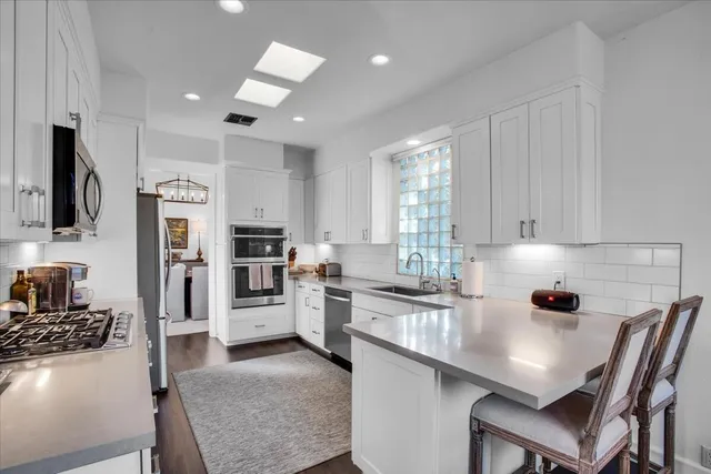 a kitchen with stainless steel appliances granite countertop a stove refrigerator sink and cabinets