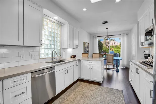 a kitchen with white cabinets and sink
