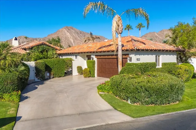 a view of a house with a yard and potted plants