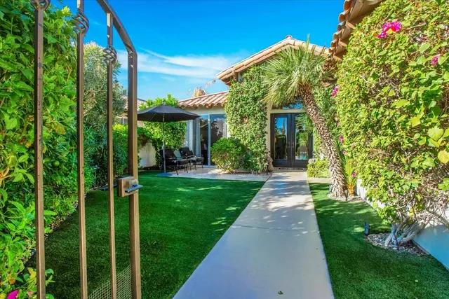 a view of a house with a yard and potted plants