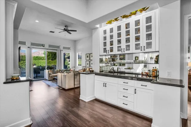 a large white kitchen with granite countertop a large window and white stainless steel appliances