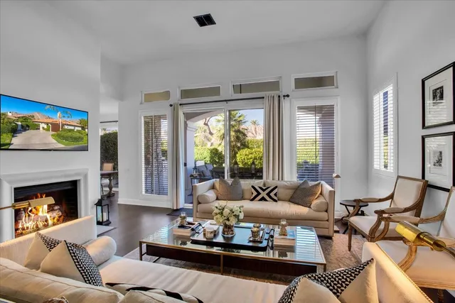 a living room with furniture fireplace and a large window