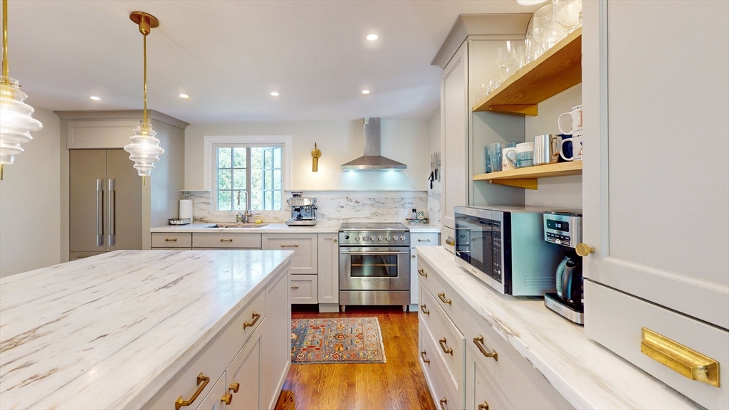 a kitchen with kitchen island granite countertop lots of counter top space and stainless steel appliances