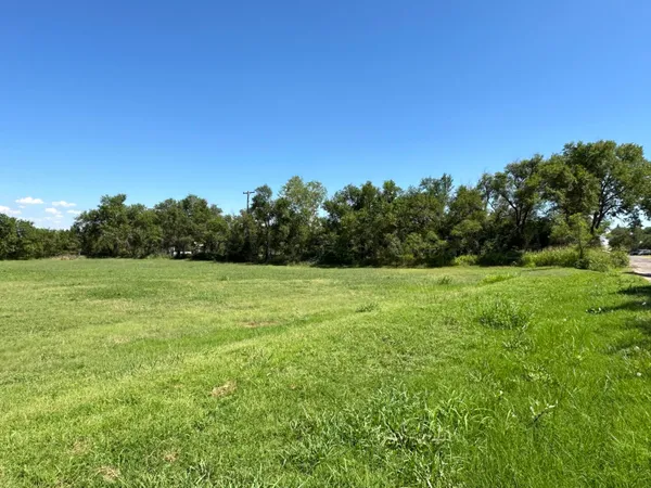 a view of a green field with wooden fence
