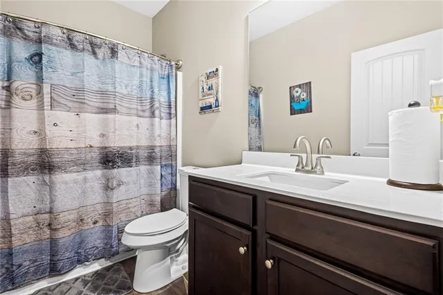 a bathroom with a granite countertop sink toilet and shower