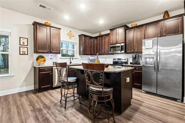 a kitchen with granite countertop a refrigerator stove top oven and sink