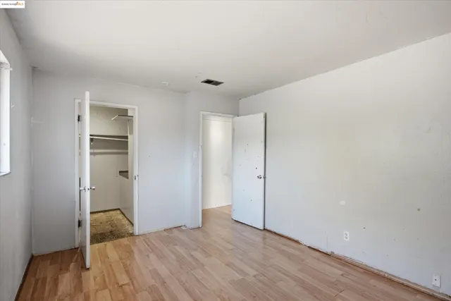 a big room with wooden floor and bathroom view