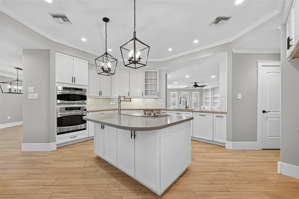 a kitchen with stainless steel appliances kitchen island a large counter space and wooden floor