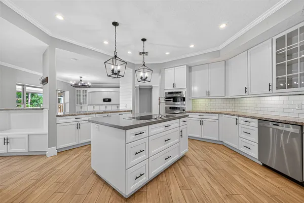 a kitchen with kitchen island granite countertop a sink cabinets and wooden floor