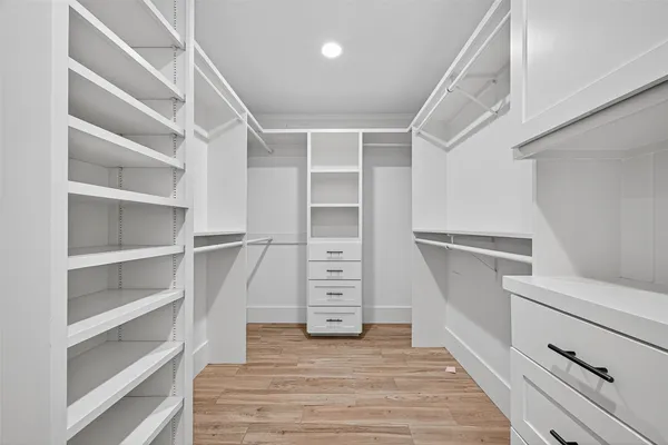 a view of walk in closet with empty racks