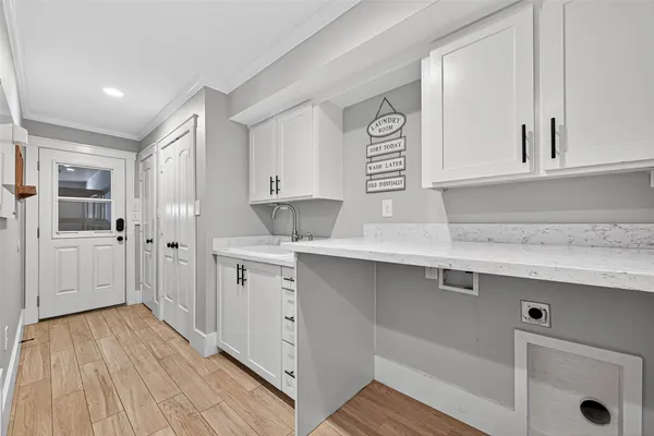 a kitchen with a sink cabinets and wooden floor