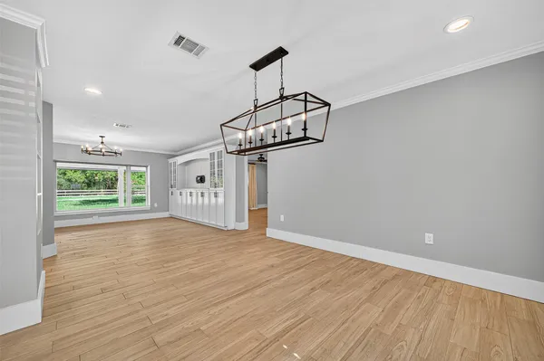 a view of empty room with wooden floor and ceiling fan