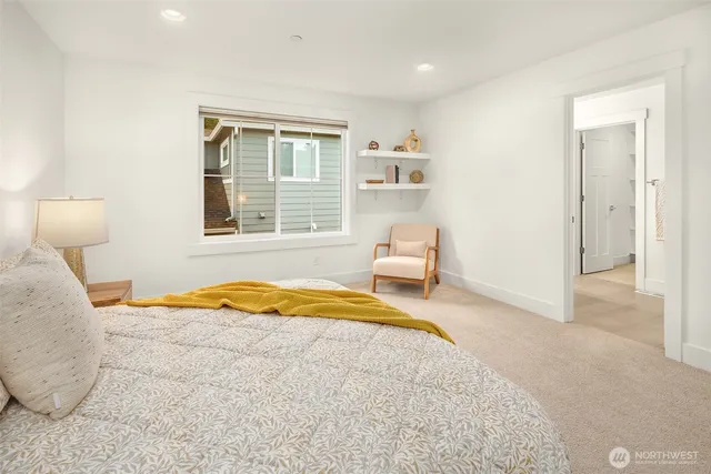 a bedroom with a bed and next to a window