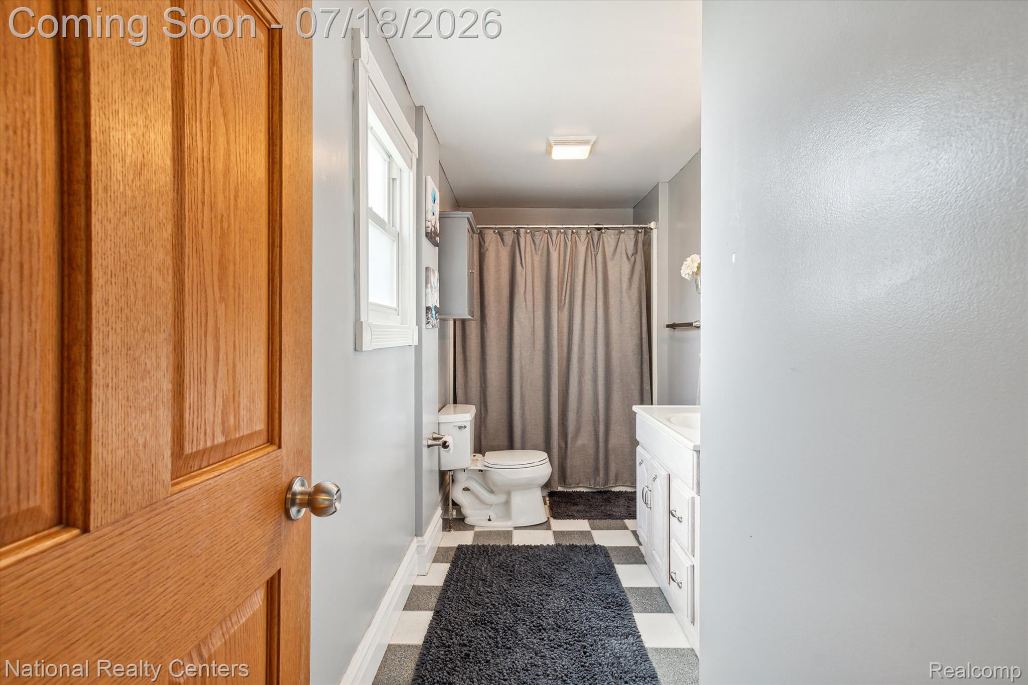 9589 Clinton Macon Road Tecumseh, MI 49286 - Photo 13 of 48 Full bathroom featuring a window, checkerboard flooring, a white vanity with storage, and a shower with a privacy curtain