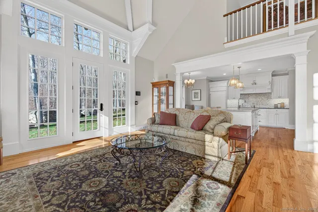 a living room with furniture wooden floor and a large window