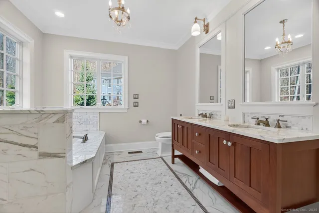 a bathroom with a double vanity sink a mirror and a bathtub