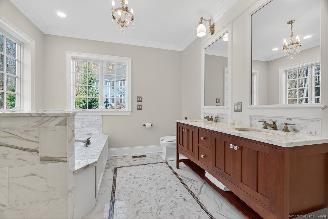 401 Fox Hopyard Road East Haddam, CT 06423 - Photo 19 of 38 a bathroom with a double vanity sink a mirror and a bathtub