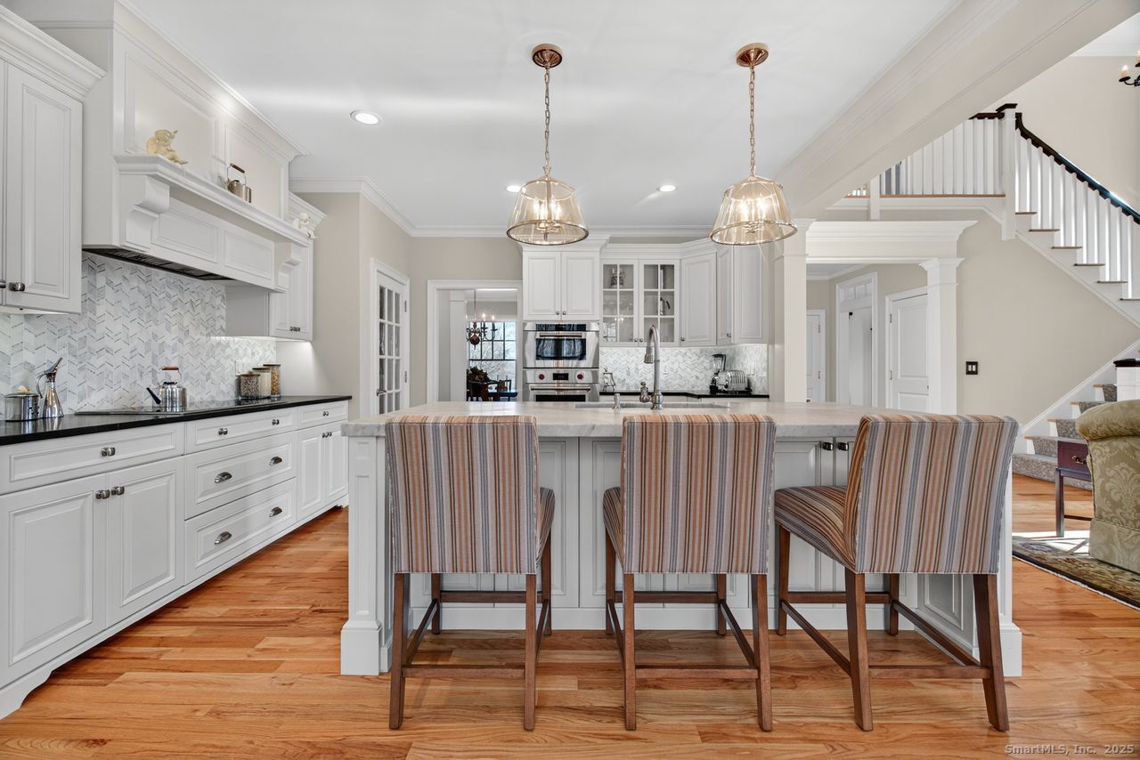 401 Fox Hopyard Road East Haddam, CT 06423 - Photo 7 of 38 a kitchen with stainless steel appliances kitchen island granite countertop a table chairs sink and cabinets