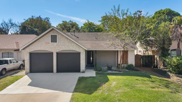 a view of a house with a yard garage and outdoor seating