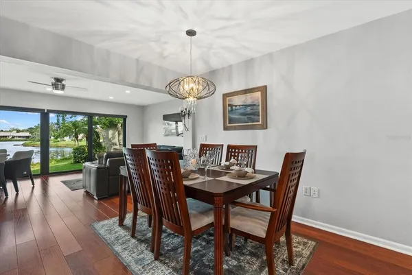 a dining room with furniture a large window and wooden floor