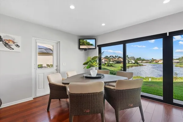 a dining room with furniture large windows and wooden floor
