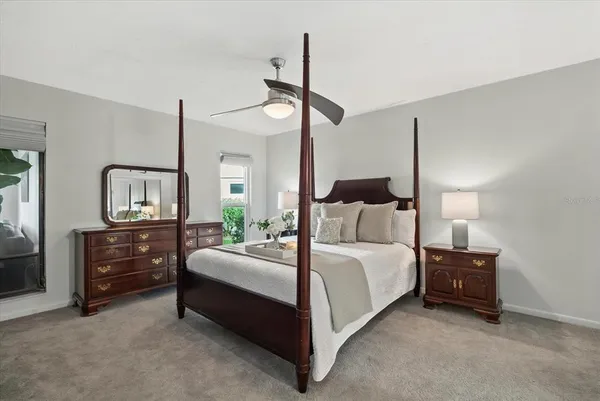 a bedroom with a bed lamp on dresser and a chandelier