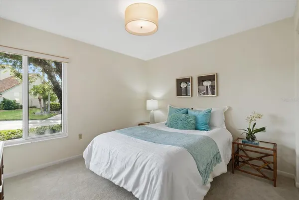 a bedroom with a large bed and a lamp next to a window