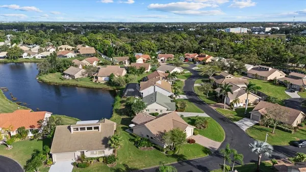 an aerial view of a residential houses with outdoor space and a lake view