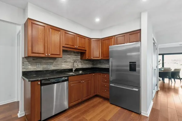 a kitchen with stainless steel appliances granite countertop a refrigerator sink and cabinets