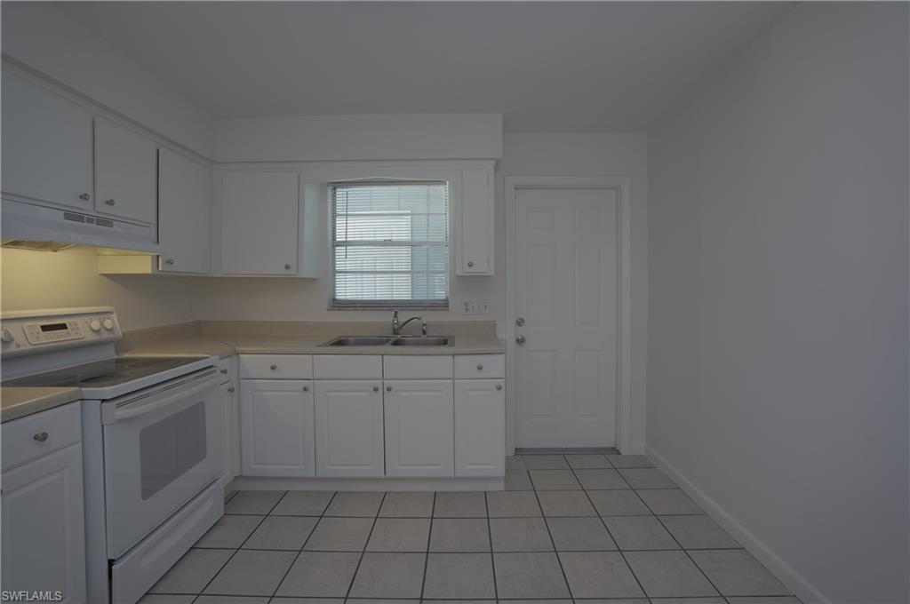 1195 South Alhambra Circle Naples, FL 34103 - Photo 11 of 34 a kitchen with a sink cabinets and window