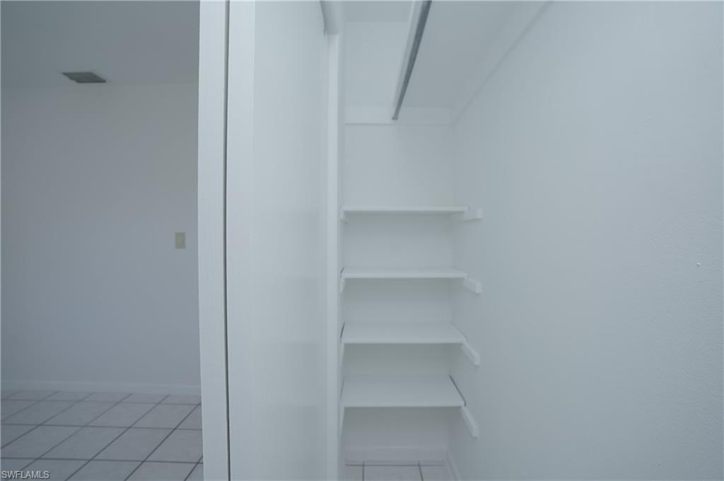 1195 South Alhambra Circle Naples, FL 34103 - Photo 23 of 34 a view of walk in closet with empty racks